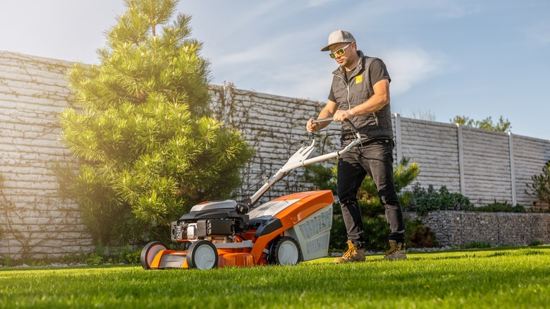 person pushing lawn mower