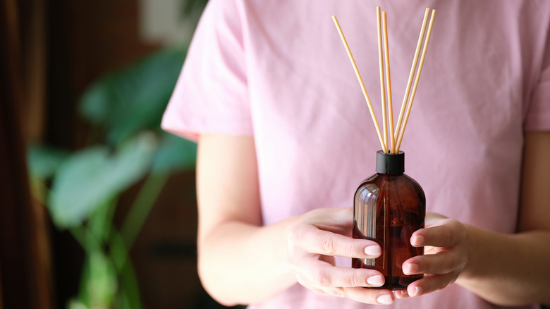 Woman holding reed diffuser