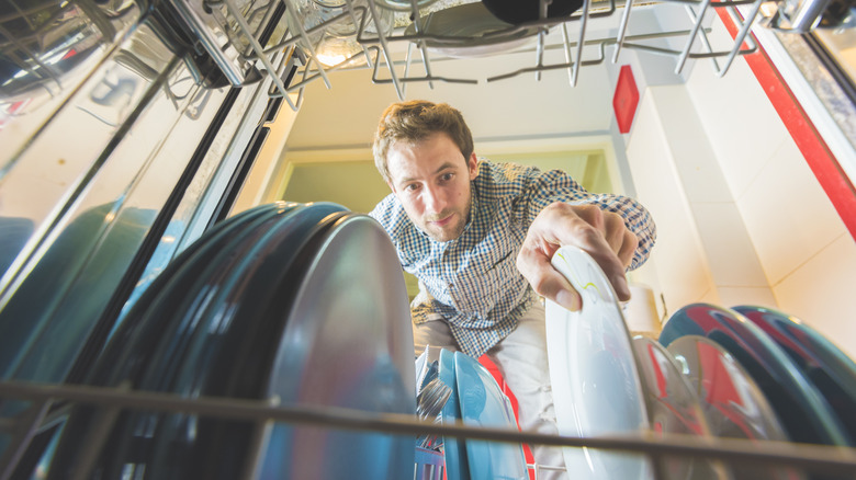 man loading dishes in dishwaser