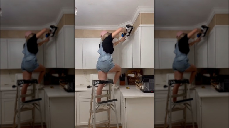 women nailing plywood over cabinets