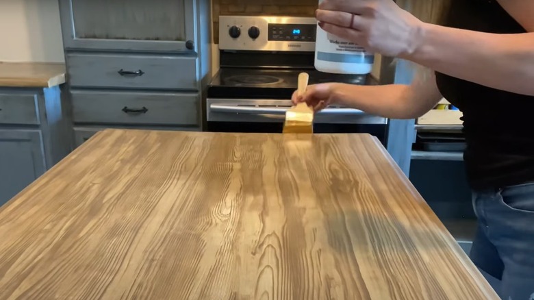 women applying stain to countertop