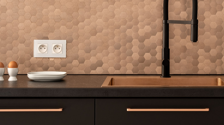 Modern copper handles on black cabinetry