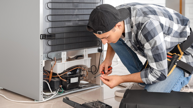 Man repairing a refrigerator