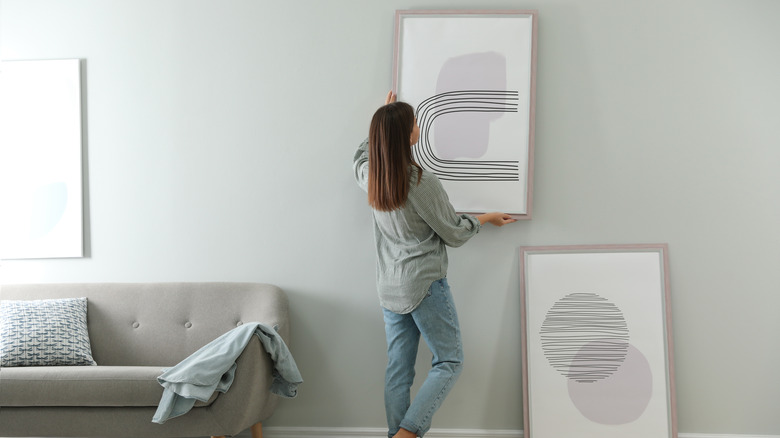 Woman hanging a picture frame