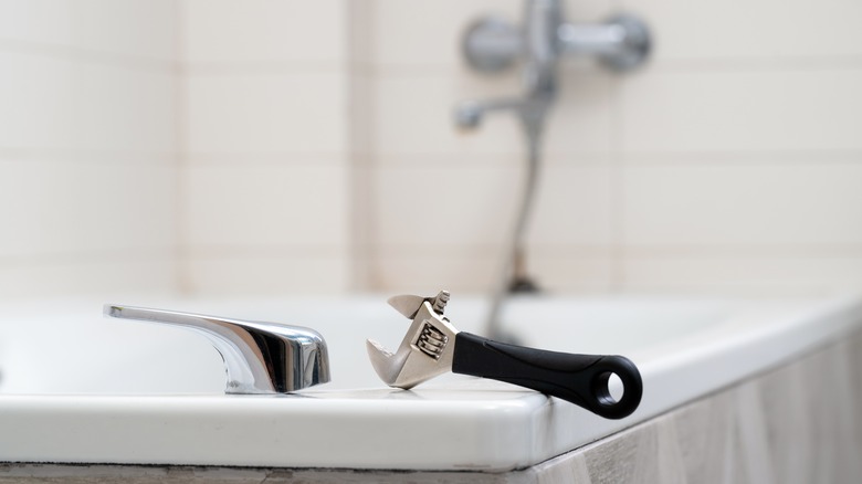 wrench on edge of bathtub