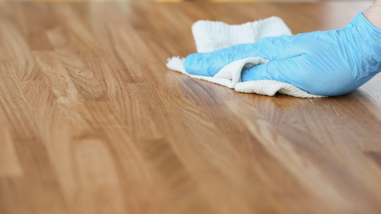 person using cloth on wood