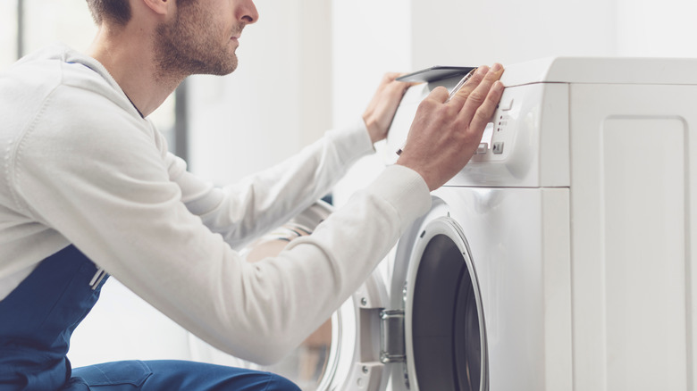 man fixing broken washer