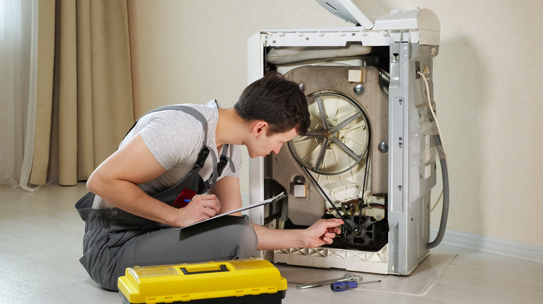 man fixing washing machine motor