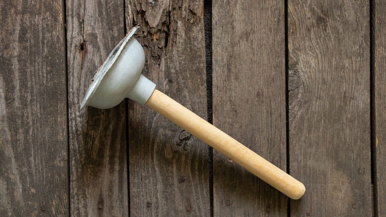 Plunger on wood background