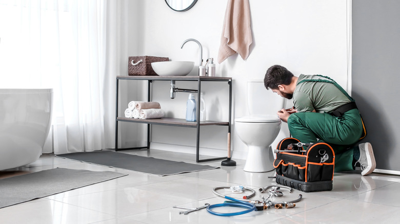 Plumber working on toilet