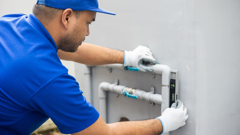 Plumber checking water tank levels