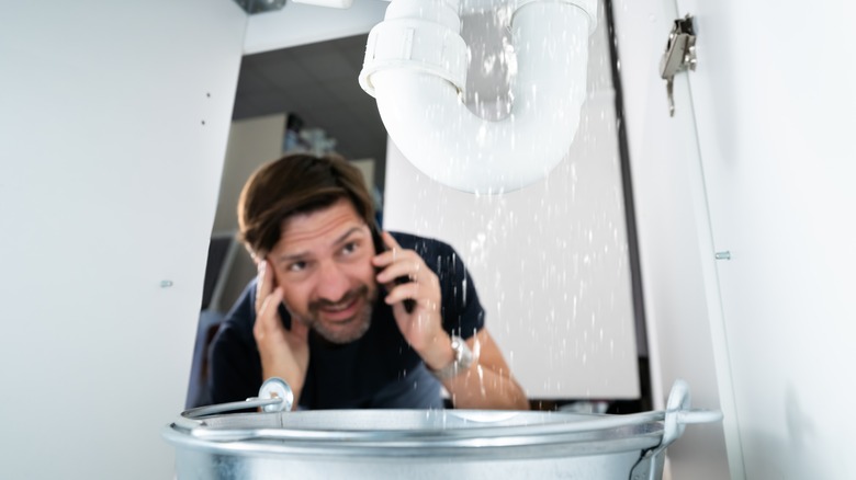 Panicked man calling plumber