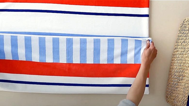 Person folding oversized striped towel