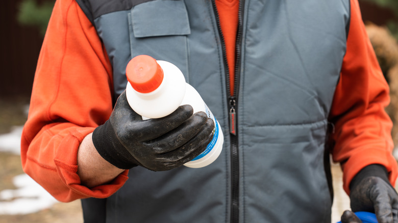 person holding bottle of herbicide