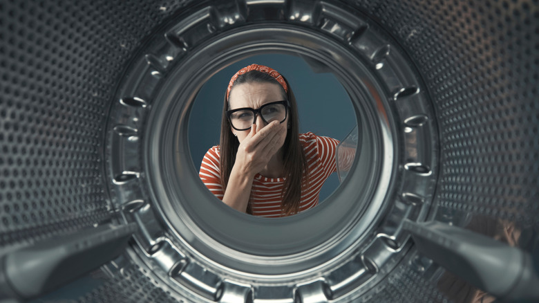 woman looking into washing machine