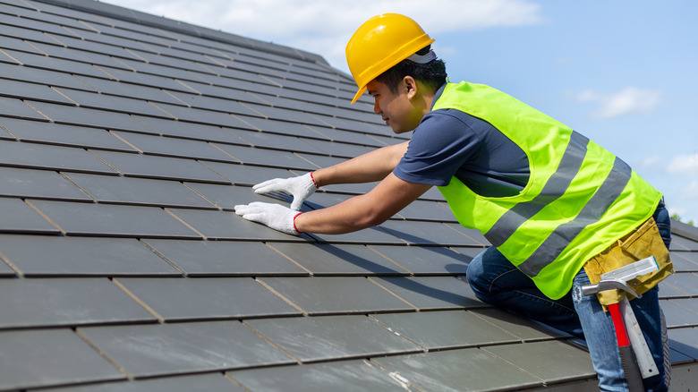 Man working on slate roof