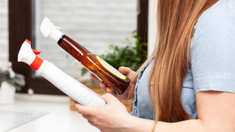 woman holding two spray bottles