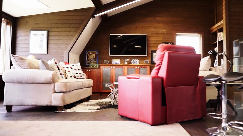 White sofa, red recliner, and TV in Mike Holmes' garage