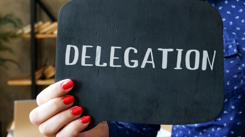 Woman holding sign that reads "delegation"