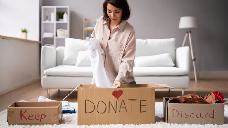 Woman with keep, donate, discard boxes