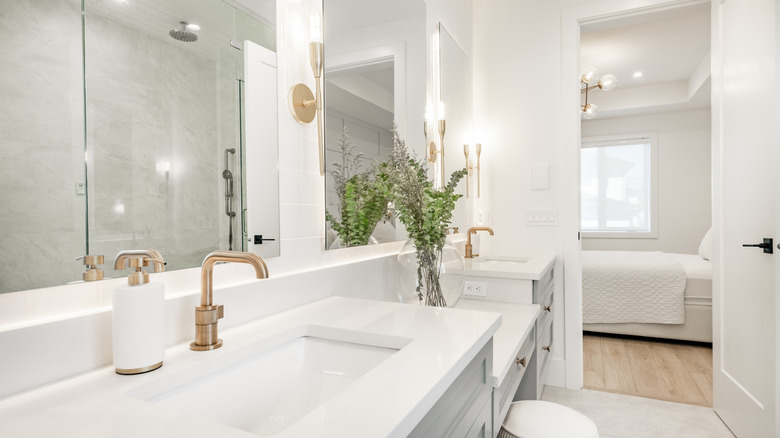 Bathroom with white countertops and gold faucet