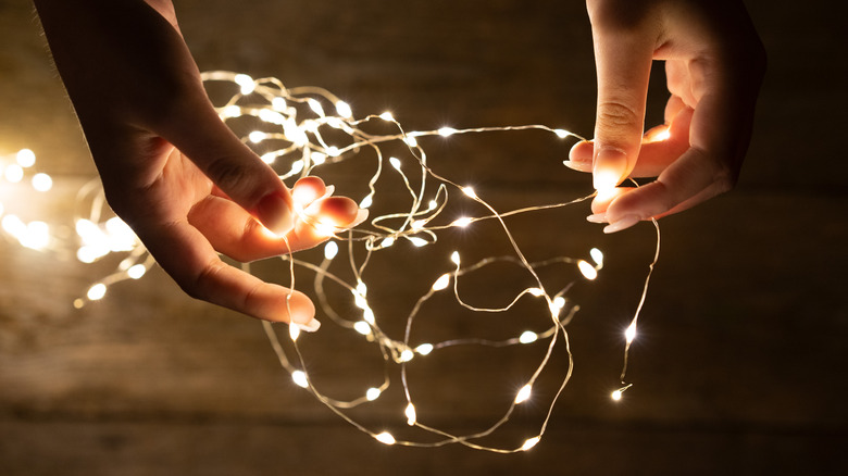 person untangling fairy lights