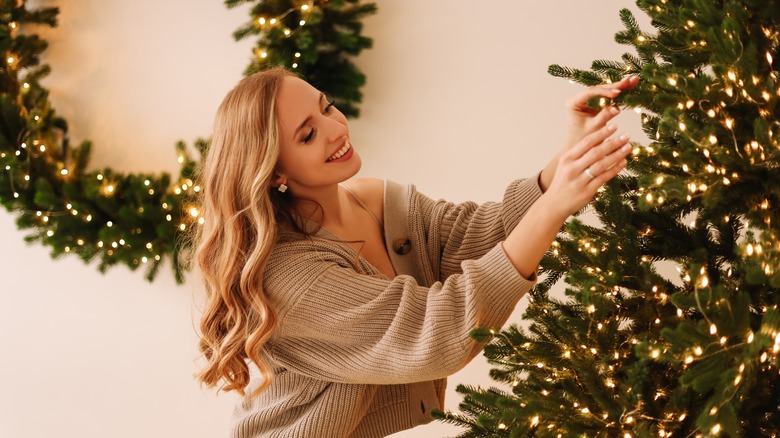 Person lighting Christmas tree