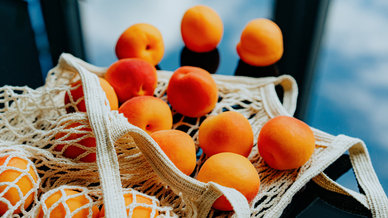 Apricots spill out of a bag and onto a table