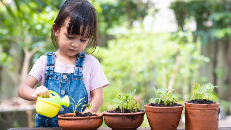 child watering and planting flowers