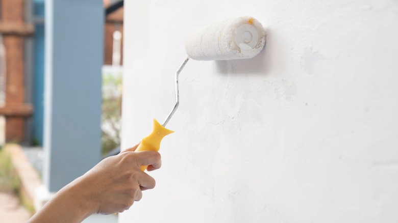 Person using roller to paint