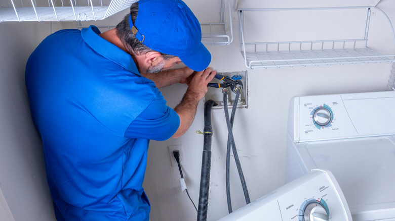 Man installing water lines for a washing machine