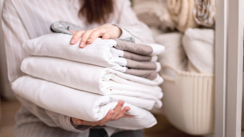 woman with neatly folded sheets