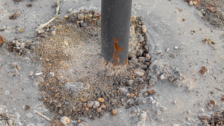 Metal fence post in concrete