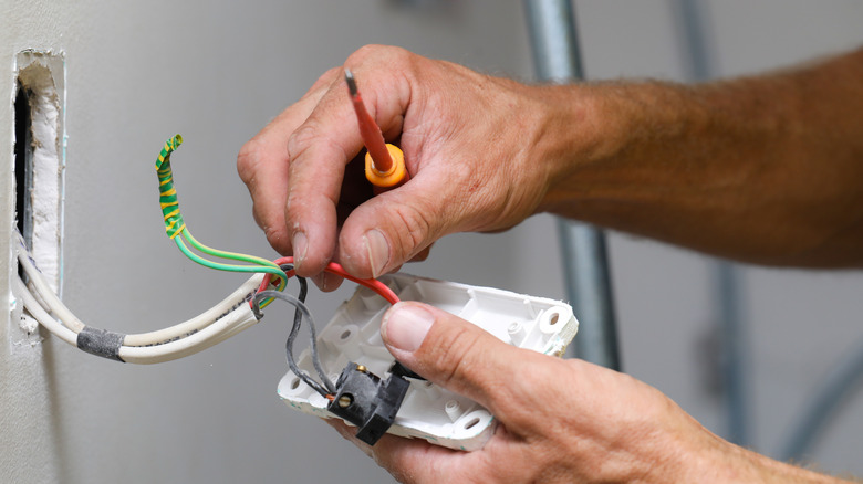 hands working on a light switch