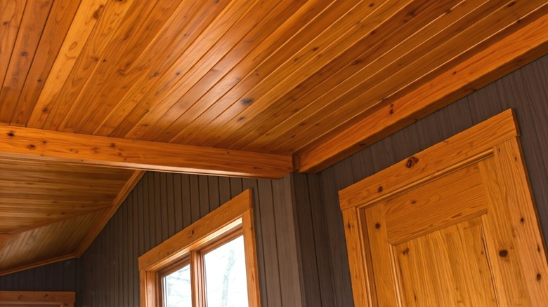 Knotty pine tongue and groove ceiling with dark gray wood paneled walls