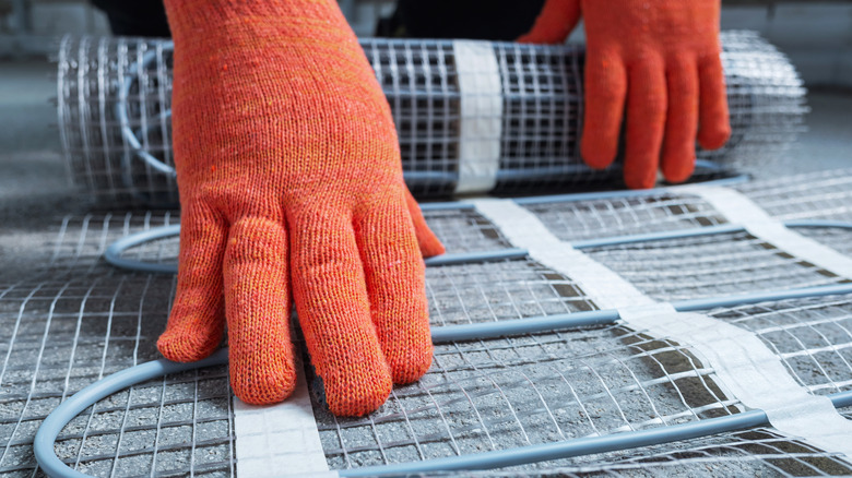 Person wearing red gloves with underfloor wires and mesh support