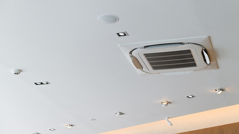 A somewhat cluttered-looking ceiling with various ceiling-mounted elements installed with uneven spacing