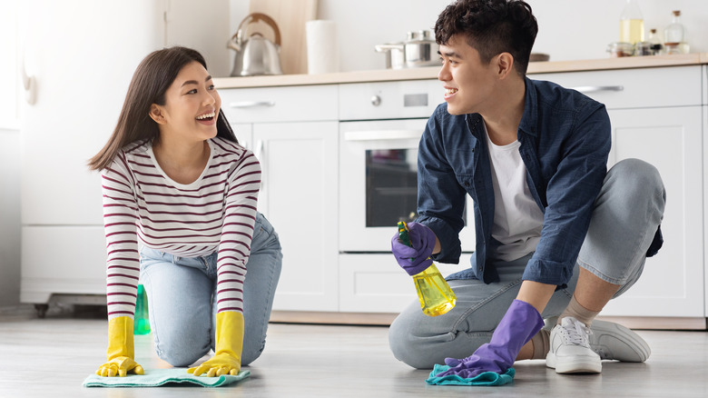 man and woman mopping floor