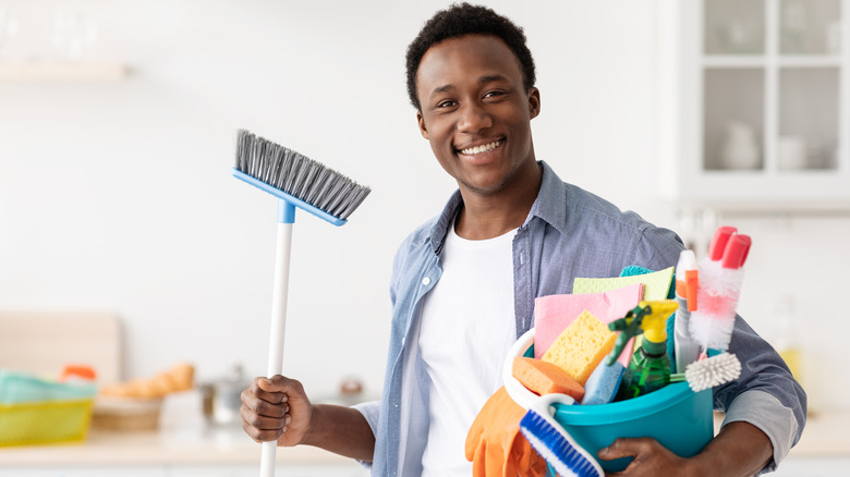 Man holding cleaning supplies