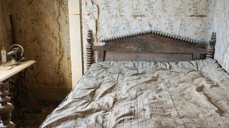 Dusty and decaying bedroom with dirty comforter