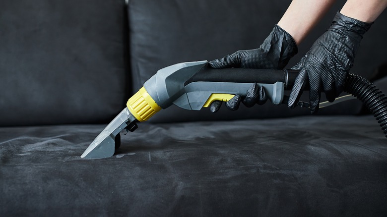 Vacuuming a black sofa