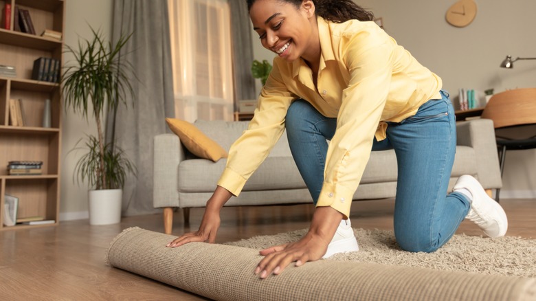 Woman unrolling rug