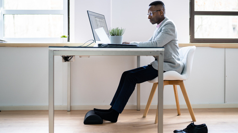 Man using desk foot rest