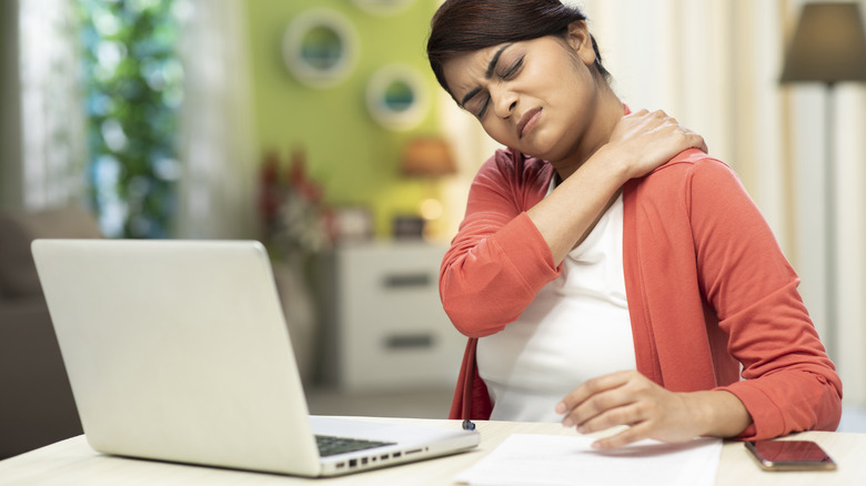 Person in pain massaging shoulder