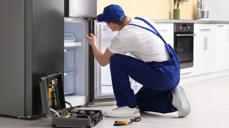 Person working to repair fridge