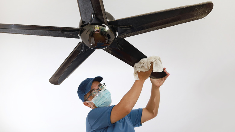 man cleaning ceiling fan