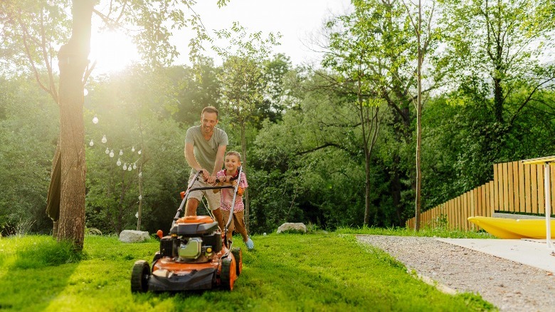 Father and son mowing lawn 