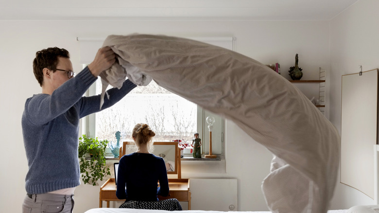 Man making a bed.