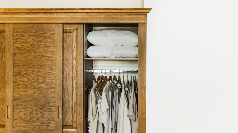 Slightly open wooden armoire with nothing on top