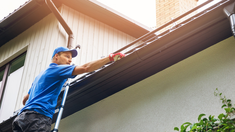 man cleaning gutters